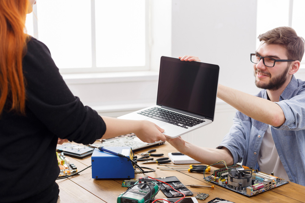 Technician Handing Laptop to Customer